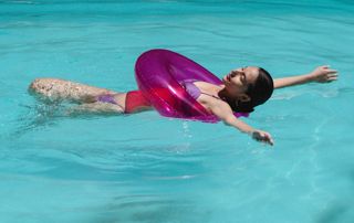 femme couchée dans l'eau avec une bouée violette