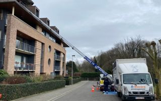 camion B-Movers avec élévateur devant une maison