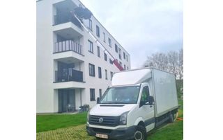 camionnette devant un immeuble avec monte-charge
