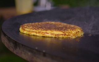cachapa cuite sur un brasero plancha