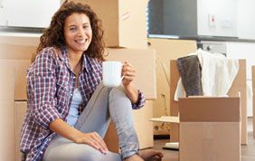 femme prenant un café après avoir emballé ses cartons