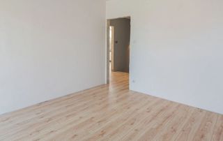pièce rénovée avec peinture murale blanche et parquet