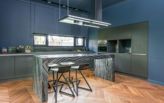 belle cuisine avec peinture murale bleue et plan de travail en marbre