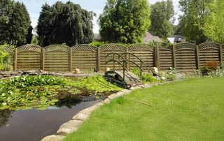 palissade en bois avec pont sur un étang