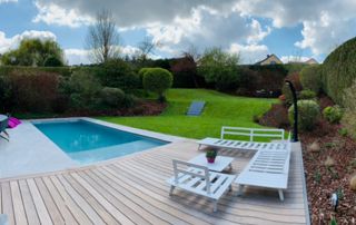 terrasse en bois au bord d'une piscine