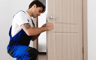 serrurier examinant la serrure d'une porte