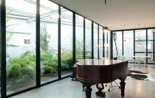 pièce avec grandes baies vitrées et piano classique