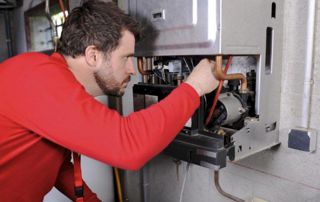 chauffagiste examinant une chaudière