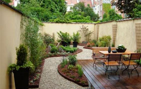 terrasse en bois, allée en pierres et meubles de jardin en bois