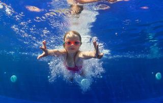 petite fille qui nage sous l'eau dans une piscine