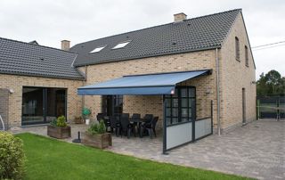 maison avec tente solaire bleue sur la terrasse