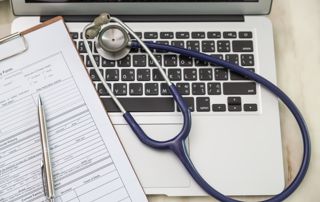 Stéthoscope et documents sur un clavier d'ordinateur portable