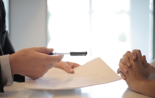 professionnel qui tend un stylo et un contrat à une personne