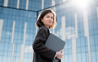 Avocate portant des documents devant un bâtiment