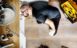 Ouvrier qui répare un évier bouché