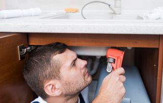 déboucheur professionnel qui examine un évier par le bas