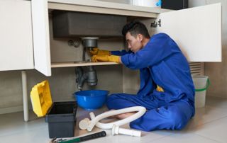 plombier débouchant un évier