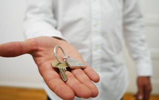 main qui donne une clé de maison