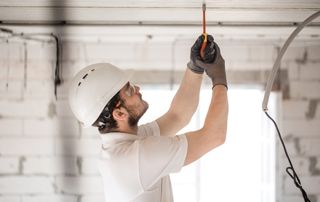 Électricien qui installe l'éclairage au plafond
