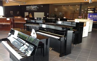 showroom avec pianos droits