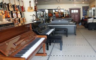 showroom avec pianos et guitares
