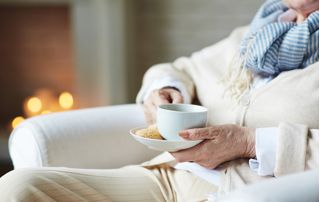 femme âgée tenant une tasse de café
