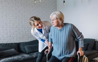 Soignante aidant une patiente à se lever