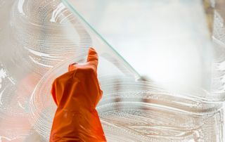 Lavage de vitre avec un gant orange
