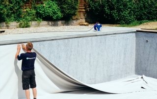 professionnel de l'entreprise Regards d'eau qui installe le revêtement d'une piscine