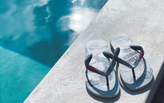 paire de tongs posée près d'une piscine