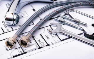 Plan de logement sur lequel sont posés un robinet, des tuyaux et des outils