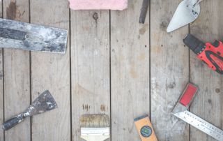 outils posés sur un plancher : pinceau, truelle...