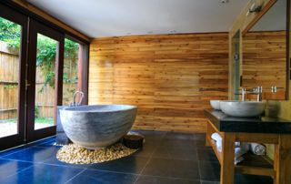 salle de bain avec mur en bois et baignoire au centre