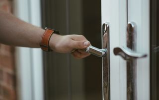 Main posée sur une poignée de porte