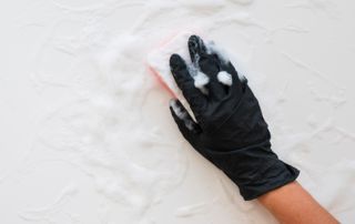 Nettoyage mur avec éponge, savon et gant