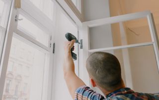 vitrier qui installe une fenêtre blanche